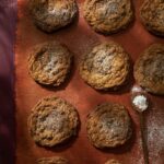 An aerial shot of six brown cookies. They are Gluten-Free 7 Spice Oatmeal and Golden Raisin Cookies.