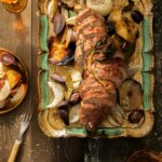 An aerial shot of Cider-Glazed Pork Loin with Roasted Apples and Potatoes in a roasting tray.