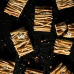 an aerial shot of eight Halloween Pumpkin Pastries laying on a black background with googly eyes attached