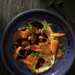 A roasted beet salad with both yellow and red beets in it, topped with vinaigrette