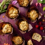 an aerial view of six veggie muffins against a purple table.