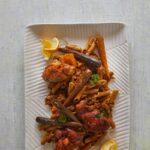 A plate of chicken harissa gluten-free pasta on a white background