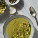 An aerial shot of a green Zucchini Soup drizzled with oil and garnished with zoodles. Zucchini Soup reicpe