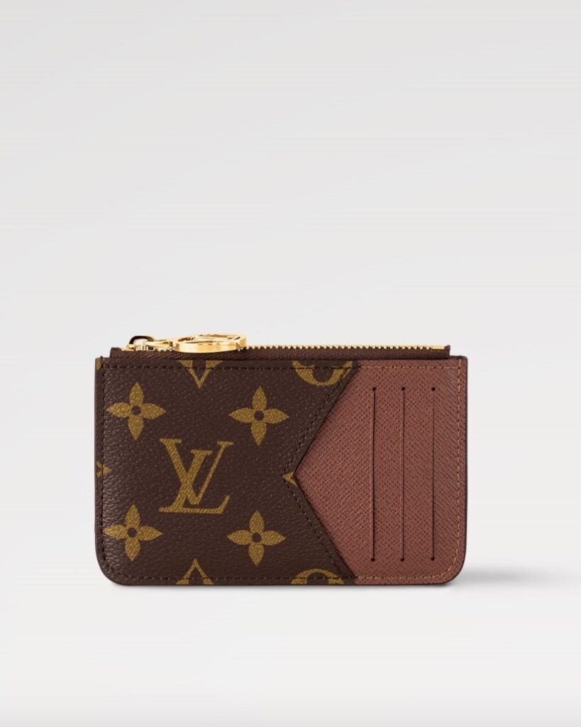 A Louis Vuitton Card Holder in brown with the VL logo on the front and a zipper on top. 