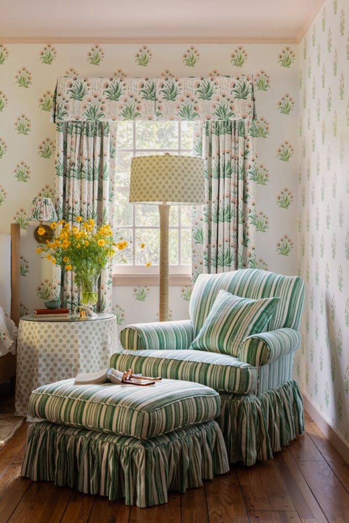 A room interior by Nathan Turner with a blue and green striped chair and ottoman in front of a similarly printed wall and curtain.