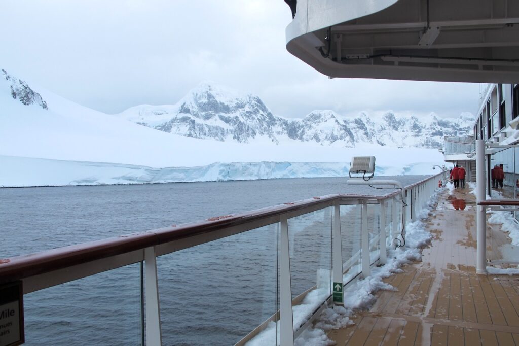 The outside of the Viking Cruise ship amongst mountains in Antarctica.