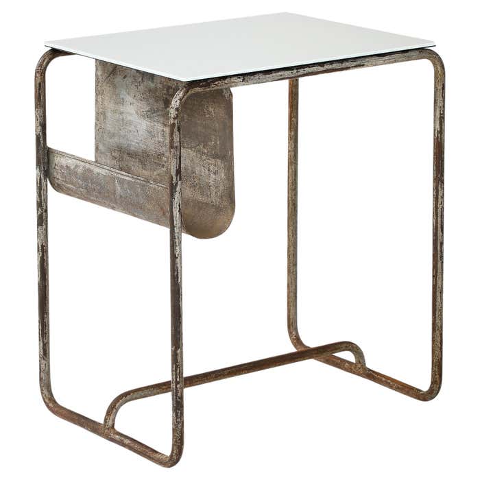 A small silver side table with a magazine rack sits against a white background.