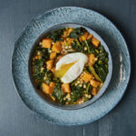 A plate of kale and sweet potato soup with a poached egg