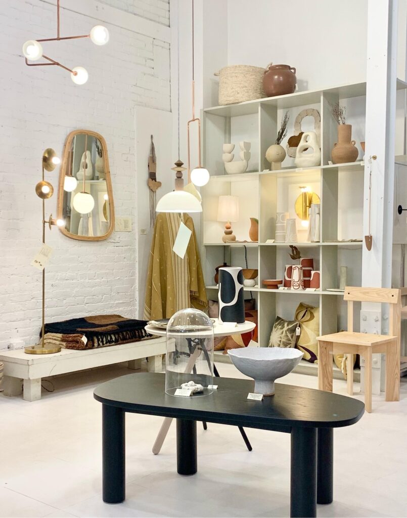 The inside of Michele Varian design shop in Boerum Hill featuring a small black table in the center and box shelves against the back wall.