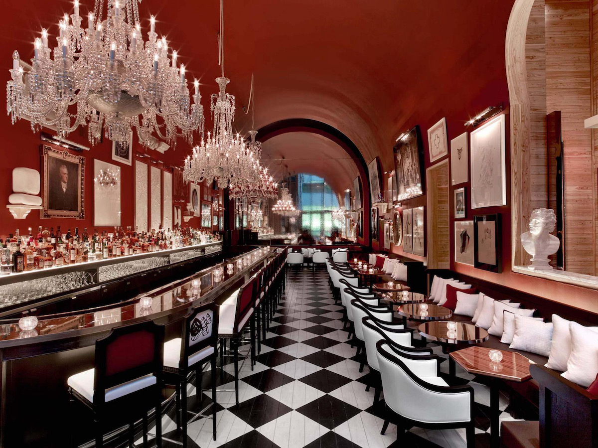 The checkered floor, chandeliers, and red walls of Baccarat Hotel