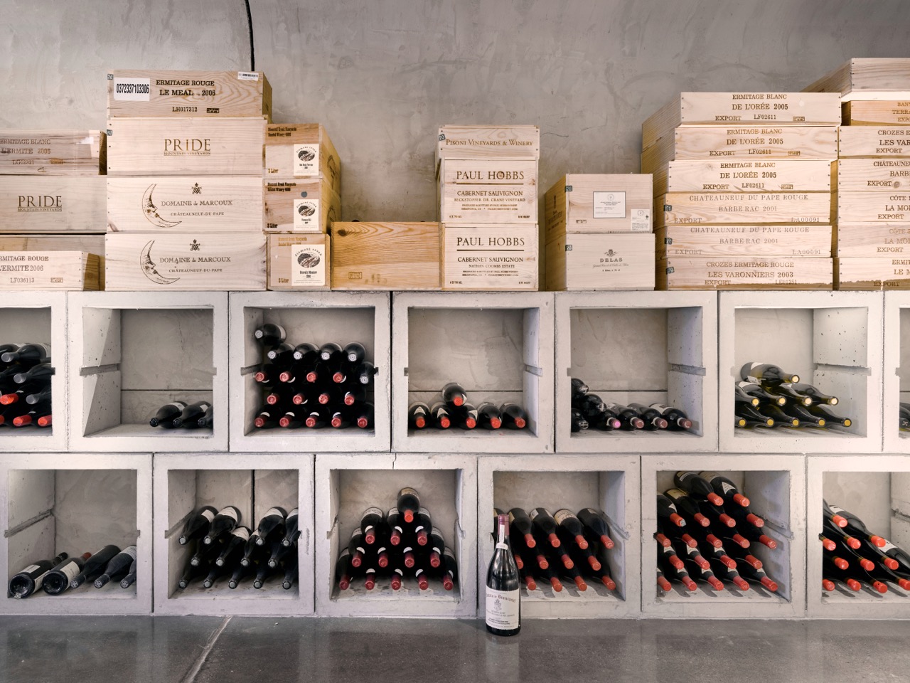 Various symmetrical wine boxes stack next to each other with bottles showing. 