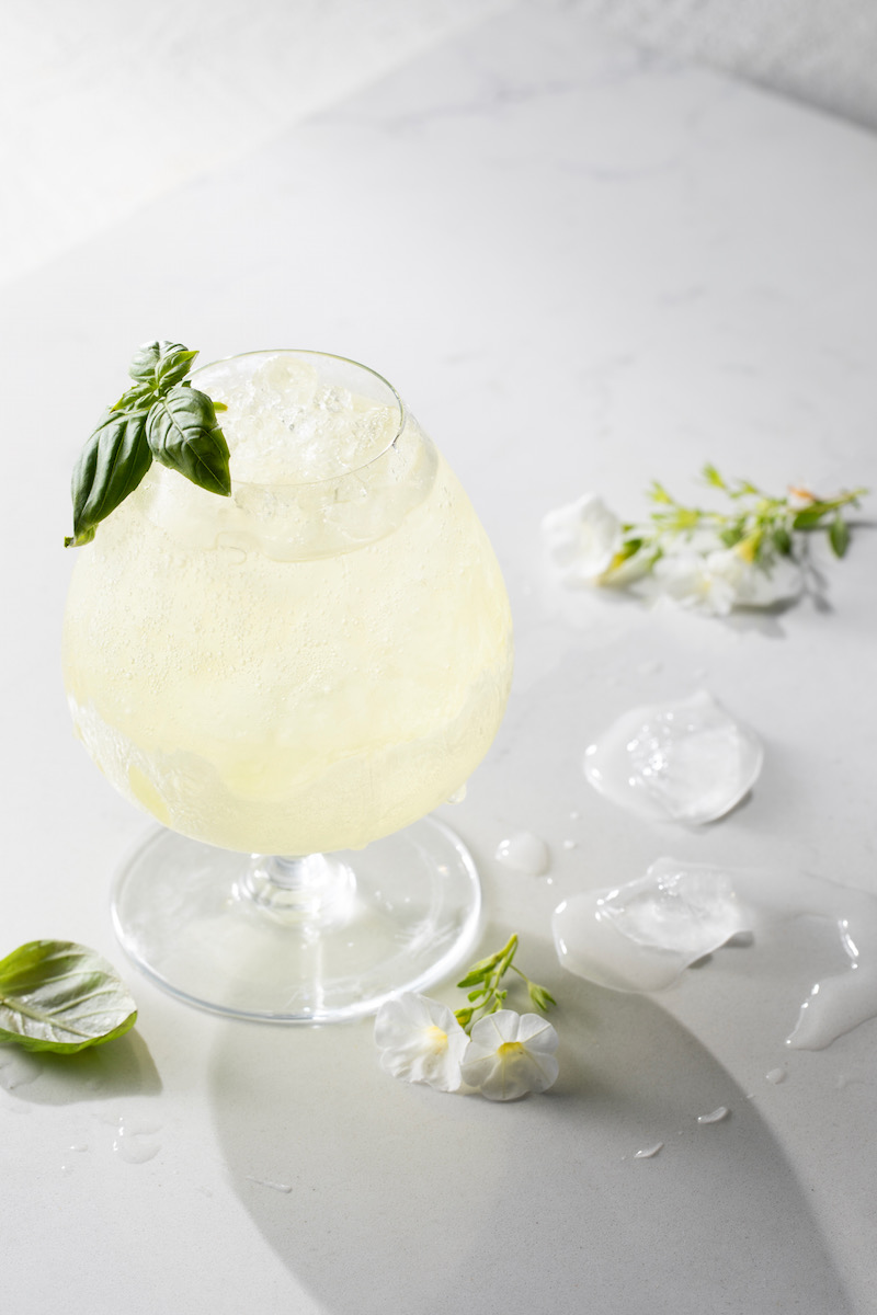 A limoncello spritzer cocktail on a white background