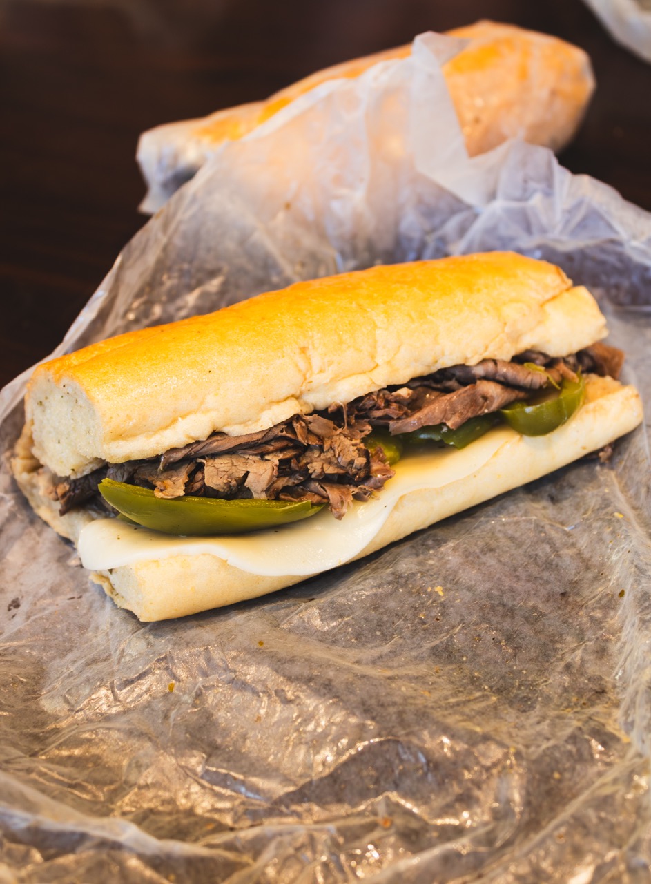 The Italian Beef Sandwich from The Bear sits on a piece of wax butcher's paper in front of another wrapped sandwich. 