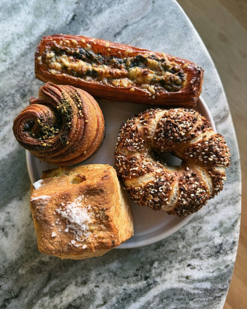 Various baked goods from Librae bakery sit on a marble round table in a small basket. 