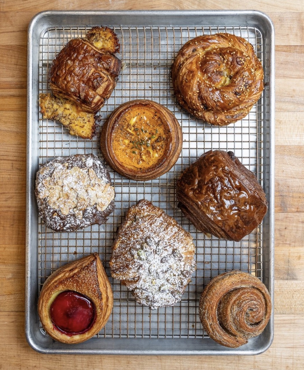 Various baked pastries from Radio Bakery sit on a baking sheet arranged in a single layer.