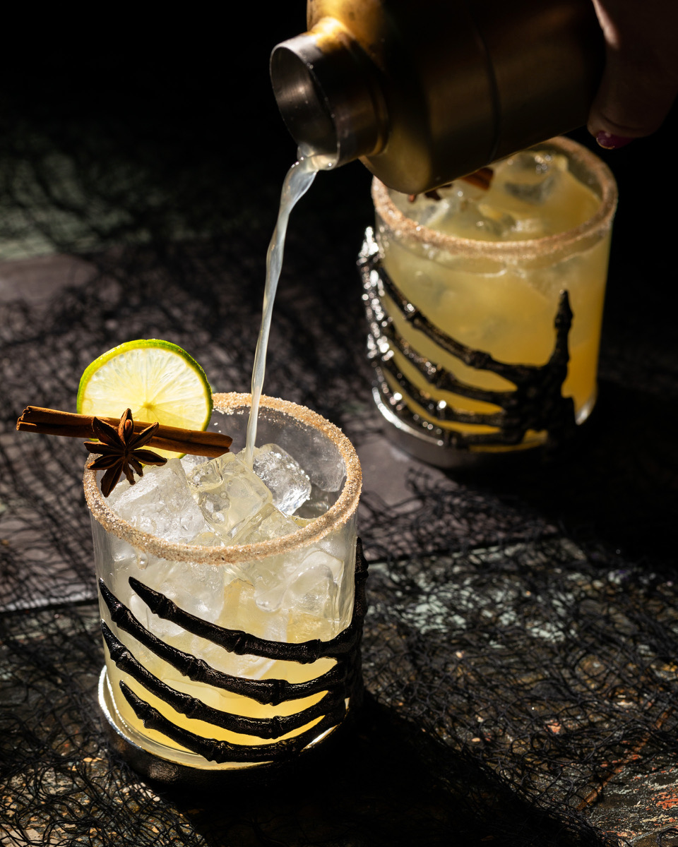 An apple cider margarita in a Halloween-inspired glass