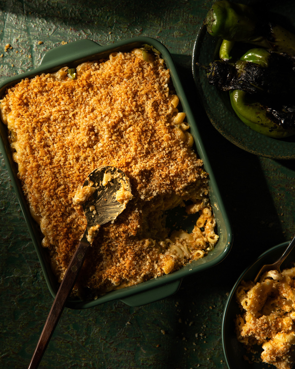 Baked mac and cheese in a pan on a dark green background