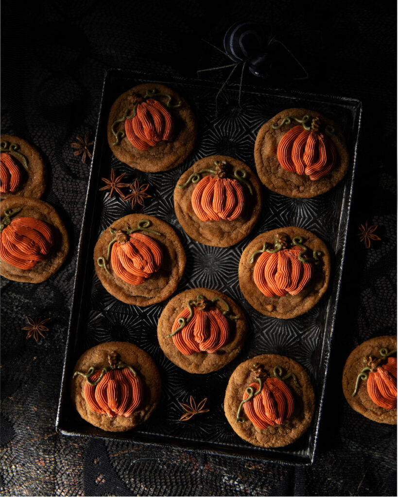 A plate of Halloween cookies on a black background