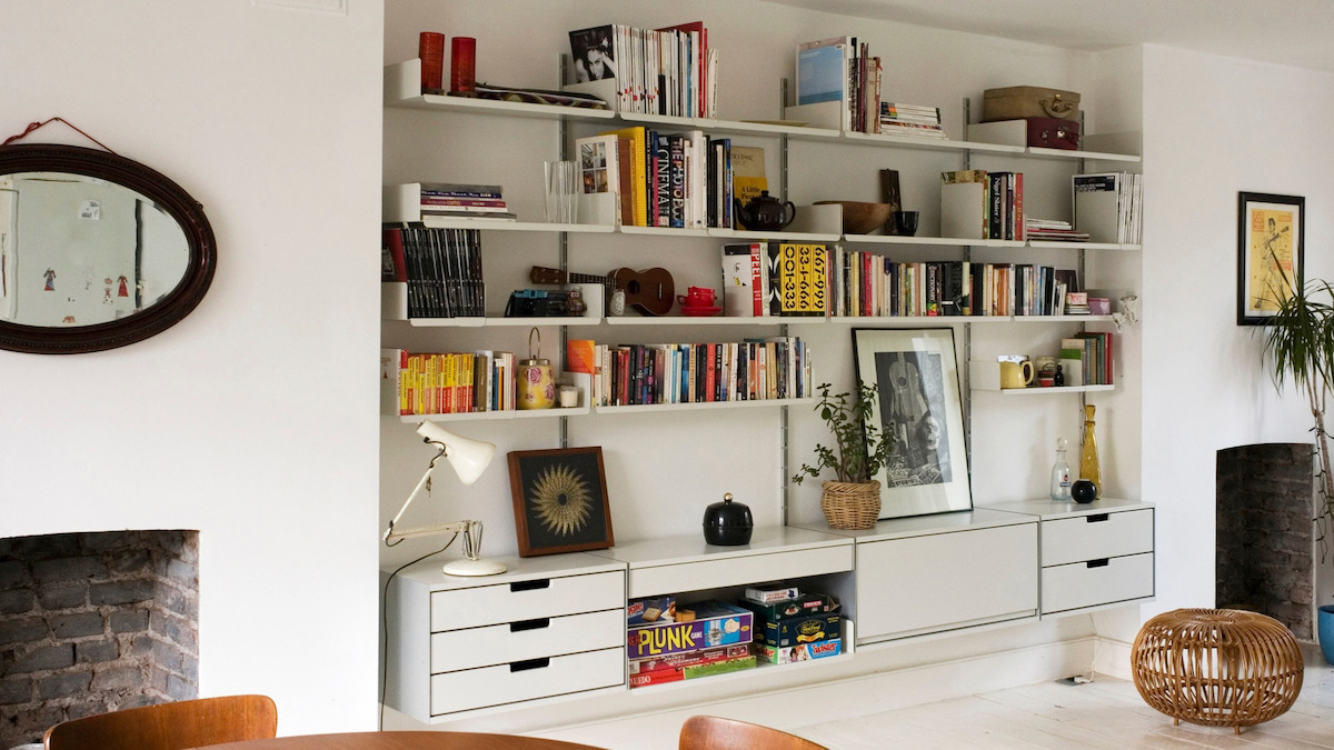 Wall organizing units on a white wall, covered in books and assorted tchotchkes 