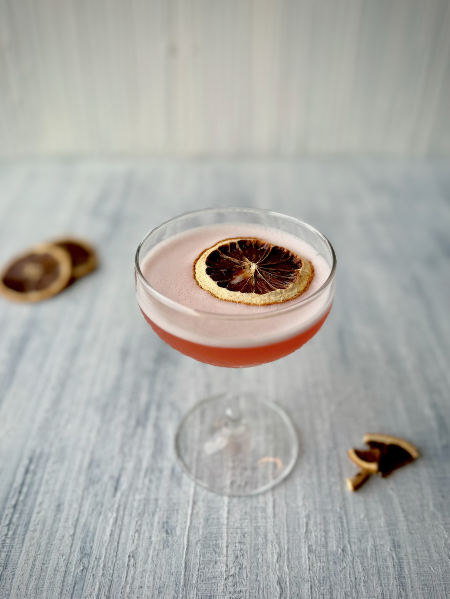 An aperol sour staged on a white background