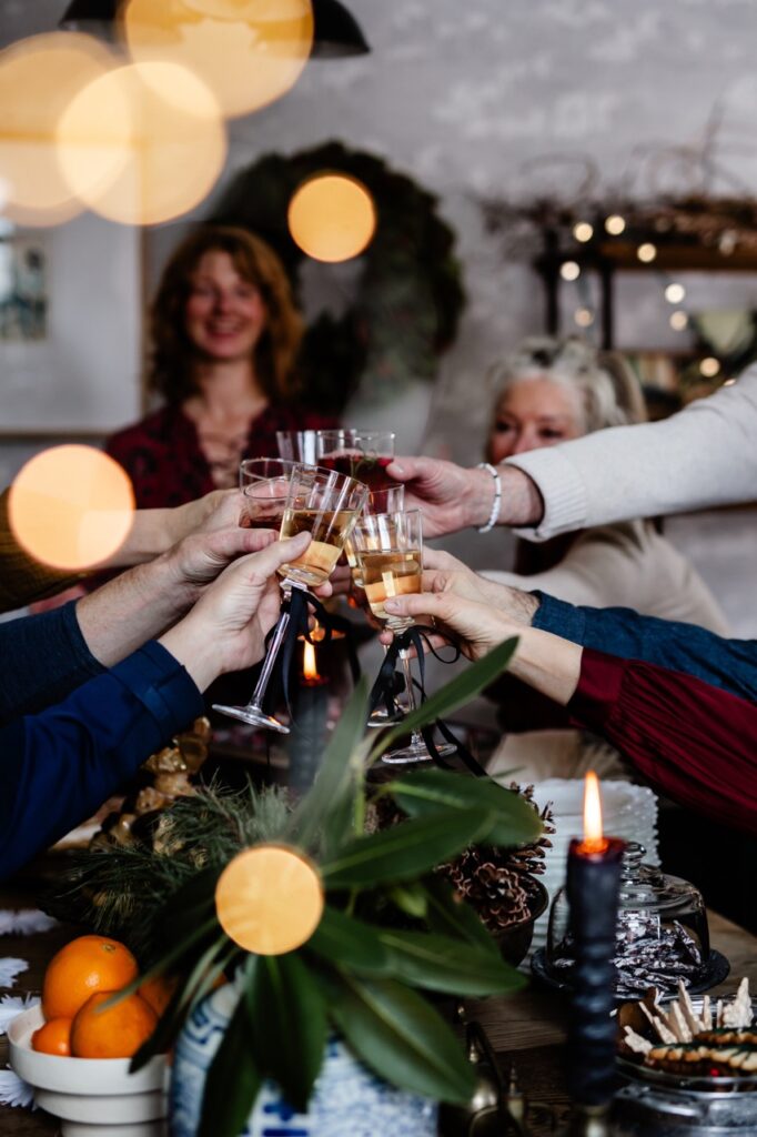 A group of people cheers champagne glasses over a table. 