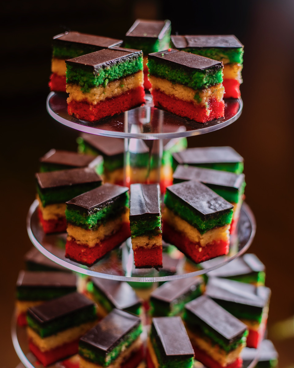 Italian rainbow cookies stacked on a tower and topped with chocolate