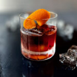 A low calorie Negroni cocktail with an orange peel in it.