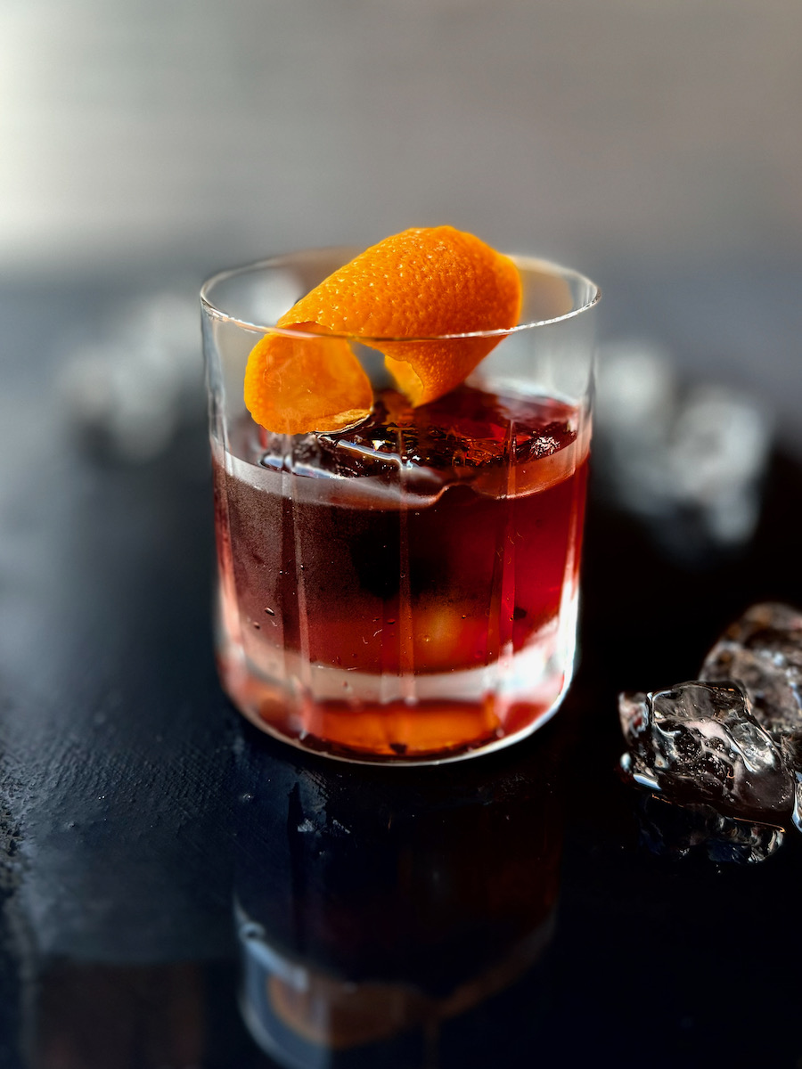 A low calorie Negroni cocktail with an orange peel in it.