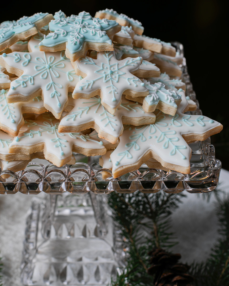 Snowflake-shaped sugar cookies on a glass tray