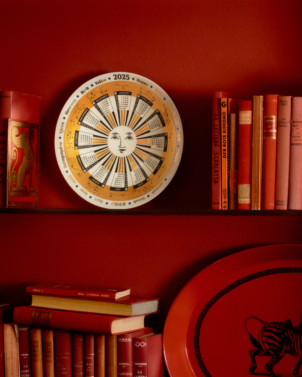 The 2025 wall plate from Fornasetti on a red wall background