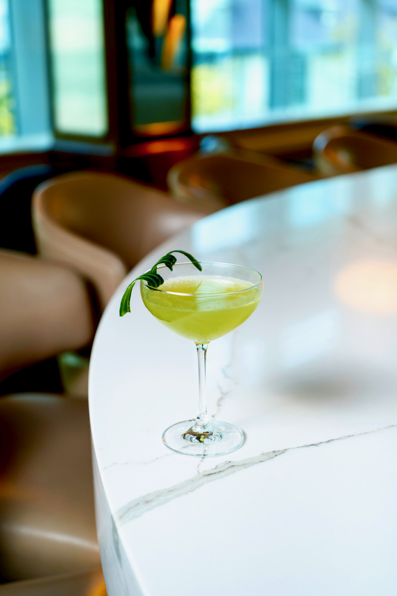 A green cocktail on a white table