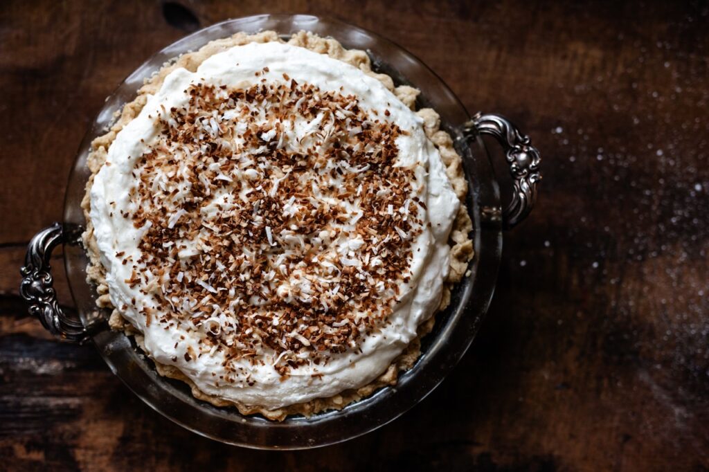 A pie with a creamy white coconut filling and toasted coconut top.