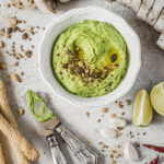 A green paste of sweet peas surrounded by bread for dipping