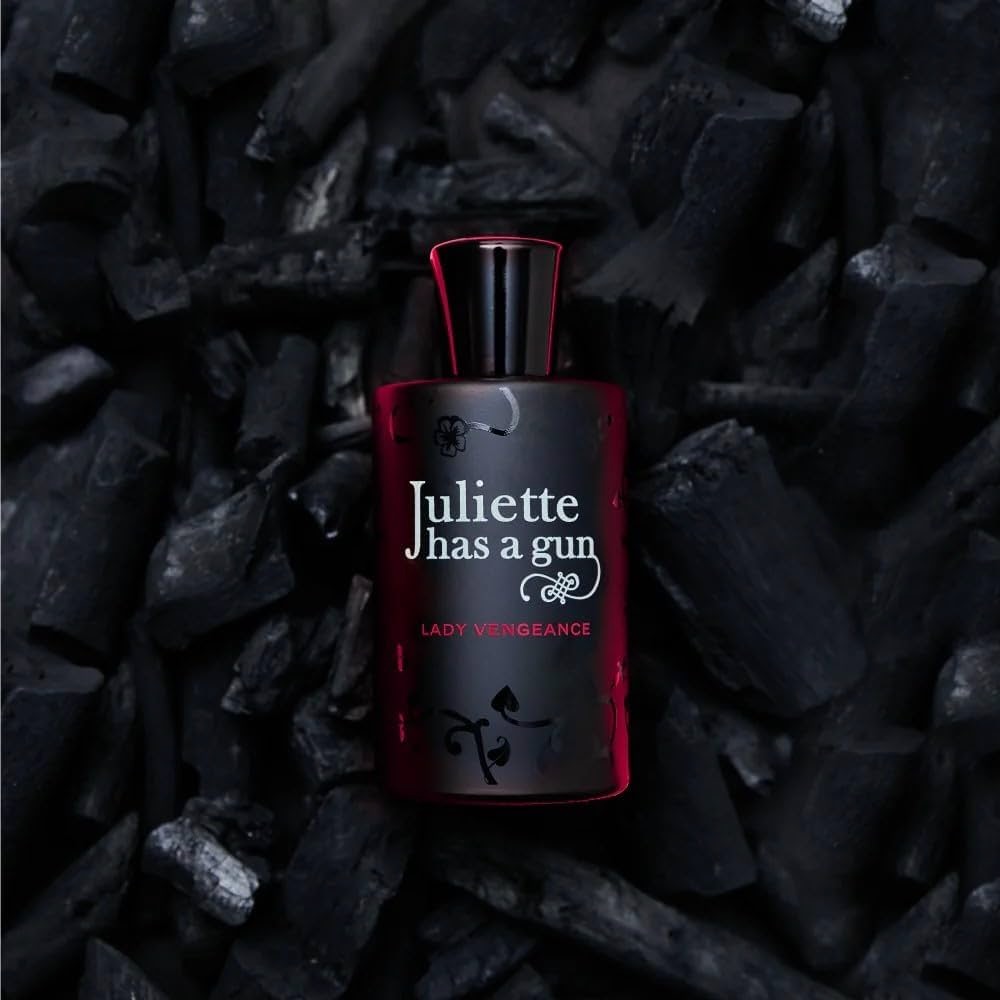 A bottle of perfume on a black background from Italian brand Juliette has a gun. 