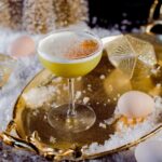 A Grey Goose cocktail staged with a few eggs and Christmas decorations for a golden, festive touch