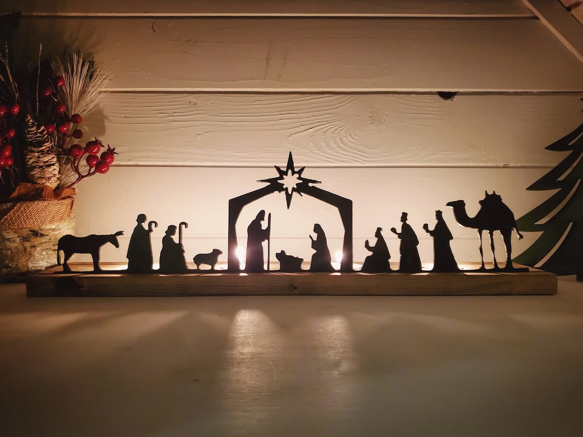 A backlit wooden nativity scene with an ombré glow