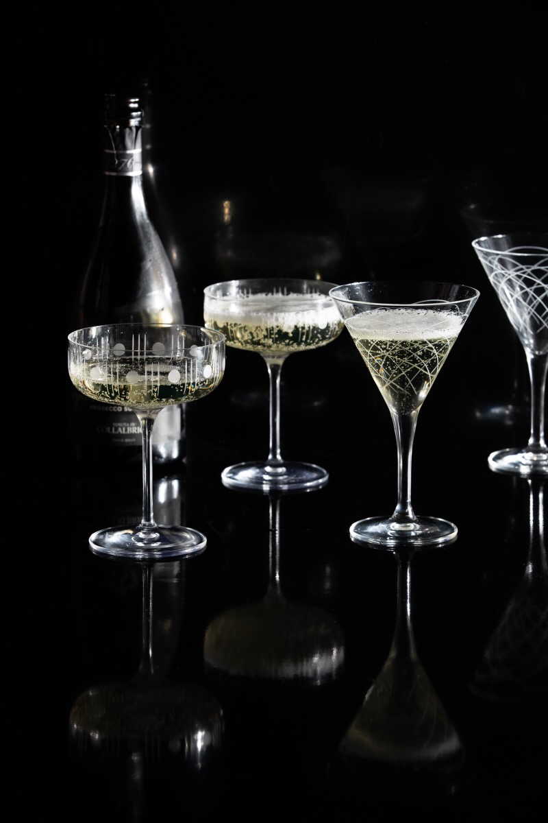 A set of full champagne glasses on a black background