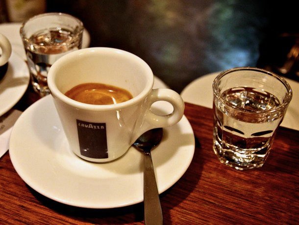 A caffe corretto (an espresso with liquor in it) set on a mahogany table.